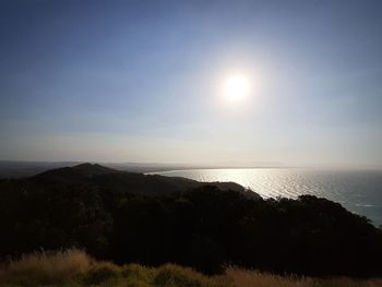 Scenic view of sea against bright sun