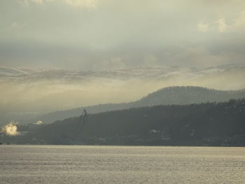 Scenic view of landscape against sky during foggy weather