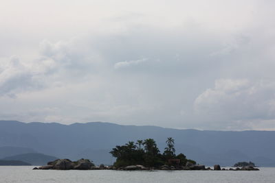 Scenic view of sea and mountains against sky