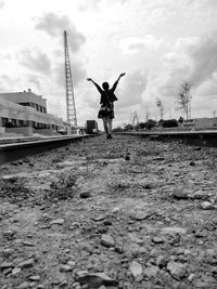 Rear view of person with arms outstretched against sky