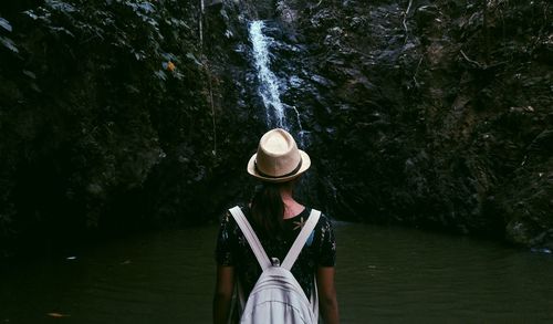 Rear view of woman standing in river