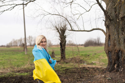 Portrait of woman with flag on field