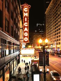 People on illuminated street at night