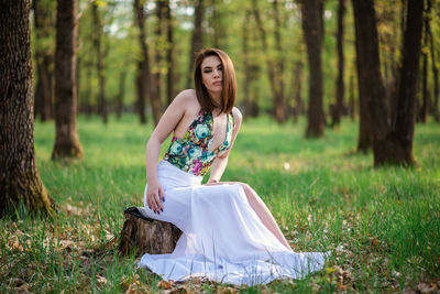 Young woman wearing hat on field in forest