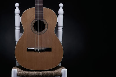 Close-up of guitar against black background