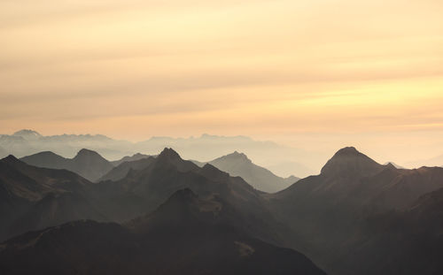 Scenic view of silhouette mountains against sky during sunset