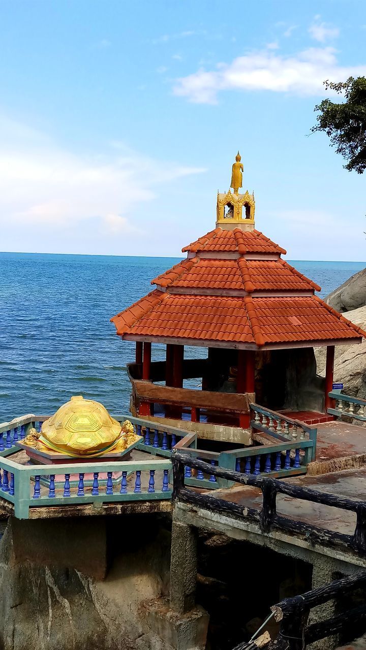 TEMPLE BY BUILDING ON SEA AGAINST SKY