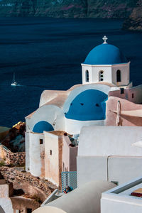 Greek white church with blue dome in santorini.