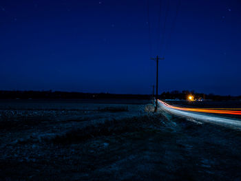 Light trails by land on road at night