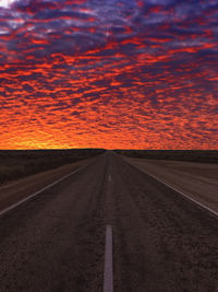 Empty road against sky during sunset