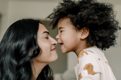 Happy daughter playing with mother at home