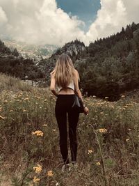 Rear view of woman standing on land against sky