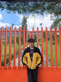 Full length portrait of young man standing against trees