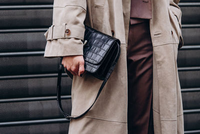 Midsection of man standing against wall