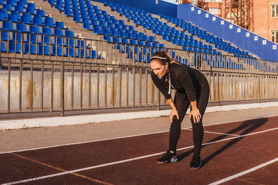 Full length of tired woman standing in stadium