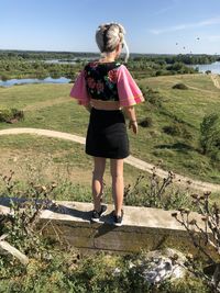 Full length of woman standing on field against sky