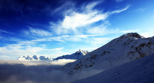 Scenic view of snowcapped mountains against blue sky