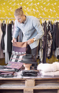 Male owner arranging cloths in clothing store