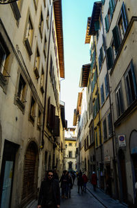 People walking on street amidst buildings in city