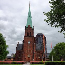 Low angle view of clock tower against cloudy sky