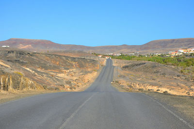 Empty road along countryside landscape