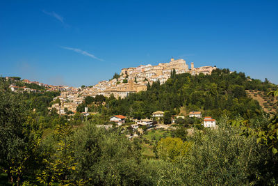 Buildings in town against blue sky