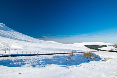 Snow covered mountain against blue sky