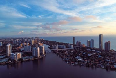 Aerial view of buildings in city against sky during sunset