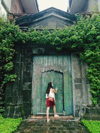 Rear view of woman standing by door