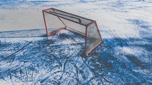 Red edged net on outdoors ice arena with hockey stick 