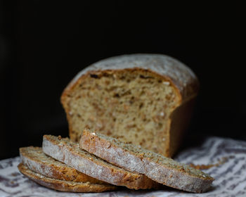 Close-up of bread on table against black background