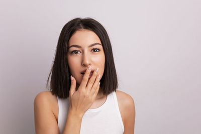 Portrait of young woman against white background