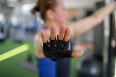 Woman wearing fingerless glove exercising in gym