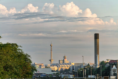 Buildings in city against cloudy sky