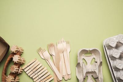 Various household items from recyclable raw materials on a green background, top view, zero waste