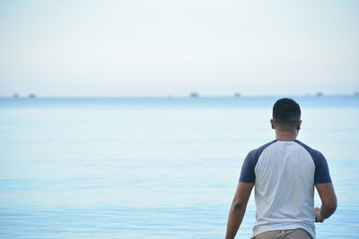 Rear view of man against sea and sky