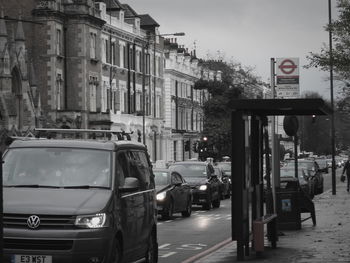 Cars on road against sky in city