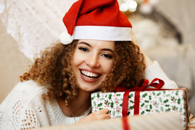 Portrait of pretty lady woman laying on christmas giftboxes wear knitted pullover and santa hat 