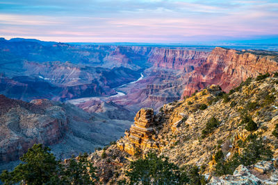 Scenic view of valley and mountains against sky during sunset