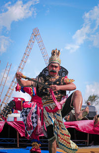 Low angle view of man dancing in costume