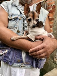 Midsection of man holding dog