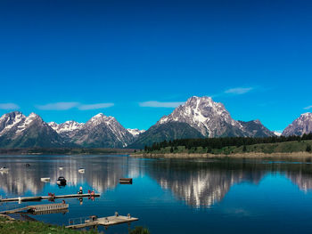 Scenic view of lake and mountains against blue sky