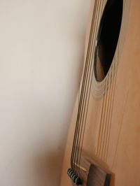 Close-up of guitar against wall