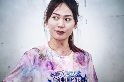 Portrait of woman standing against wall