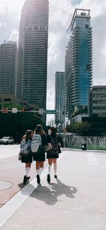 People on street against modern buildings in city