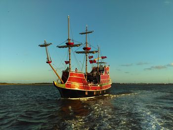 Red dragon pirate cruises on sea against sky