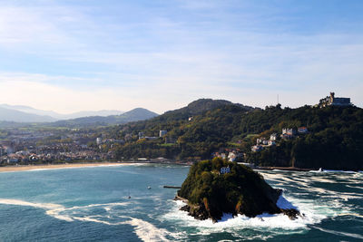 Scenic view of sea and mountains against sky