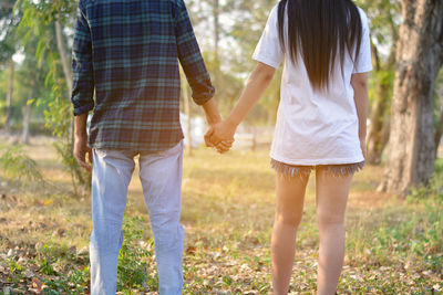 Rear view of couple holding hands