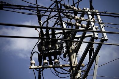 Low angle view of electricity pylon against sky