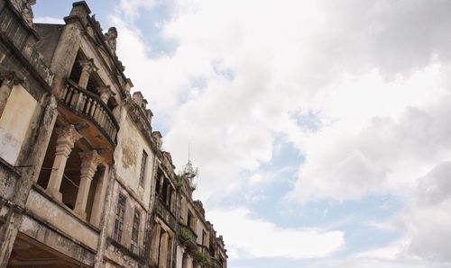 Low angle view of old building against cloudy sky